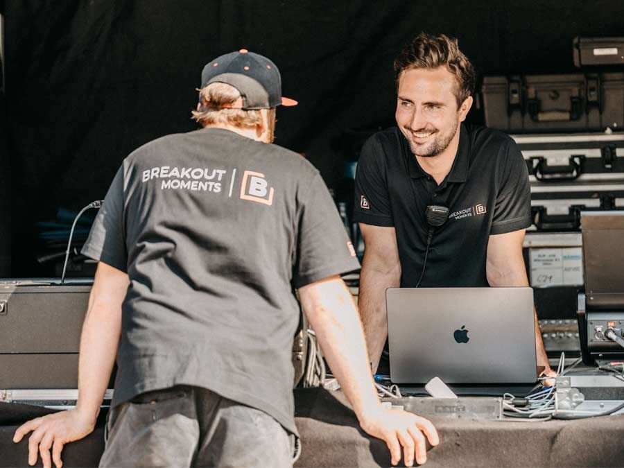 zwei Männer die sich über ein technisches Pult unterhalten