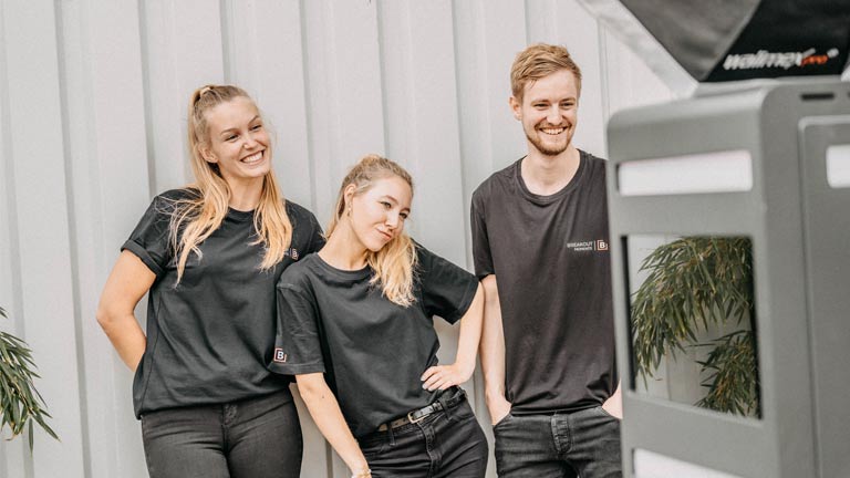 3 Personen vor einer Fotobox die Spaß haben